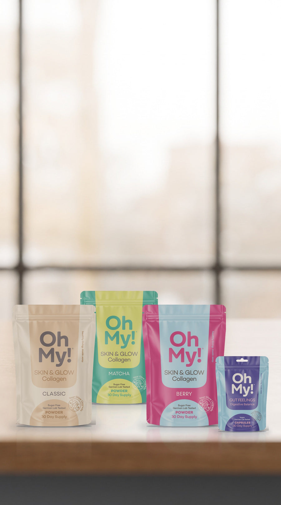 OhMy! Skin & Glow Collagen in Classic, Matcha und Berry und Gut Feelings auf einem Eichentisch im Morgenlicht